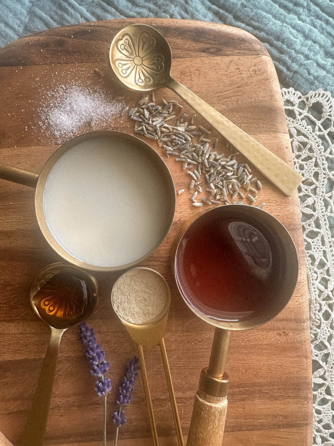 Flat lay of natural ingredients for herbal bedtime tea including lavender, ashwagandha powder, tart cherry juice, almond milk, coconut milk, and raw honey